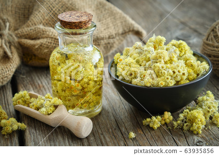 Helichrysum infusion bottle, immortelle flowers 63935856