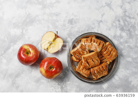 Puff pastry cookies filled with Apple jam and fresh red apples on light concrete background Puff pastry cookies filled with Apple jam and fresh red apples on light concrete background 63936159