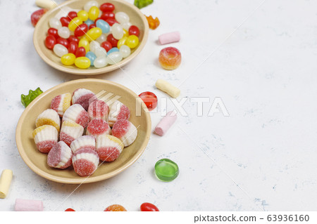 Colorful candies, jelly,marshmallow on light background. Top view with copy space Colorful candies, jelly,marshmallow on light background. Top view with copy space 63936160