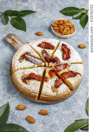 Homemade rustic plum cake with powdered sugar and almond,top view 63936202