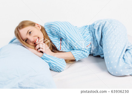 Happy young girl in striped pajamas sleeping on a - Stock Photo