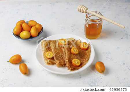 Delicious Breakfast on light background. Orthodox holiday Maslenitsa. Crepes with cumquats and honet,top view 63936373