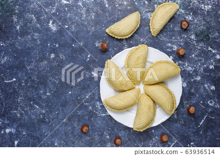 Azerbaijan national pastry shakarbura on white plate on dark background ,top view,spring new year celebration Novruz holiday. 63936514