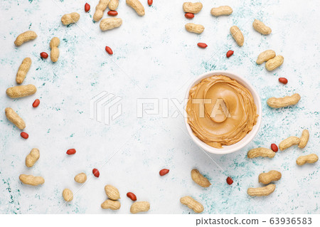 Homemade peanut butter with peanuts on grey concrete background,top view 63936583