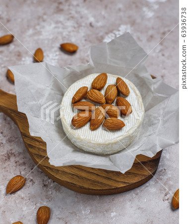 Camembert cheese with cheese knife on board on brown concrete background Camembert cheese with cheese knife on board on brown concrete background 63936738