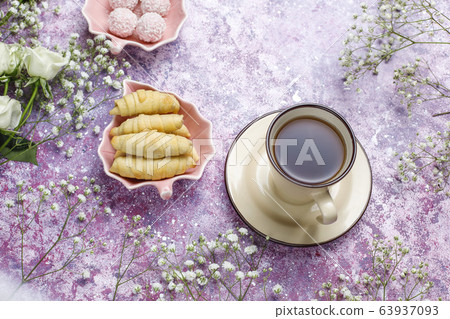 March 8 Women's Day card with white flowers,sweets and a cup of tea on light background. March 8 Women's Day card with white flowers,sweets and a cup of tea on light background. 63937093