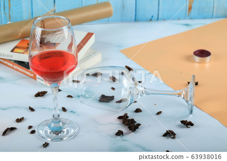 Red rose in a glass and an empty wine glass on the cardboard 63938016