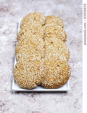 American style sesame seed cookies on light concrete background. 63938859