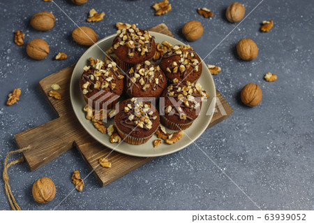 Chocolate-walnut muffins with coffee cup with walnuts on dark background ,Selective Focus. Chocolate-walnut muffins with coffee cup with walnuts on dark background ,Selective Focus. 63939052