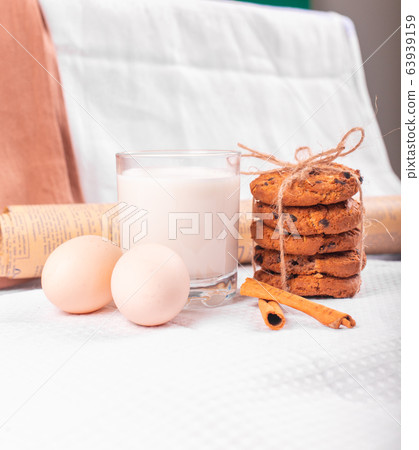 A glass of milk with caramel cookies and raw eggs 63939159