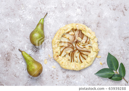 Homemade pear galette pie with almond leaves and fresh ripe green pears 63939288