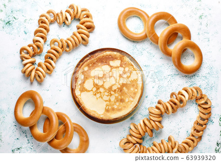 Shrovetide Maslenitsa festival meal. Russian pancake blini with raspberry jam, honey, fresh cream and red caviar,sugar cubes,cottage cheese,bubliks on light background 63939320