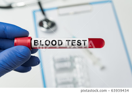 Hand in medical glove holding blood test. Tube of 63939434