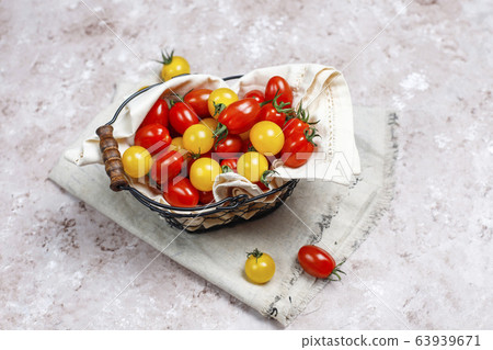 Cherry tomatoes of various colors,yellow and red cherry tomatoes in a basket on light background 63939671
