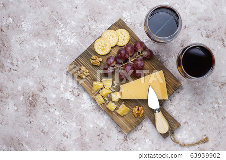 cheese board with hard cheese ,cheese knife,red wine glass,grape on brown concrete background cheese board with hard cheese ,cheese knife,red wine glass,grape on brown concrete background 63939902