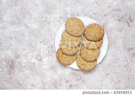 American style sesame seed cookies on light concrete background. 63939953