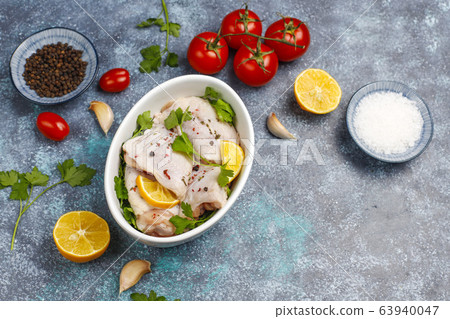 Raw chicken thighs with spices parsley on wooden cutting board,top view 63940047