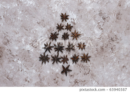 Organic homemade dried orange chips slices,nuts,star anise,cinnamon sticks on light brown background,top view Organic homemade dried orange chips slices,nuts,star anise,cinnamon sticks on light brown background,top view 63940387