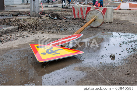 a road sign lies on a ruined city street 63940595
