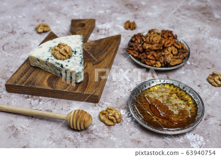 blue cheese on wooden cutting board with honey and walnuts 63940754