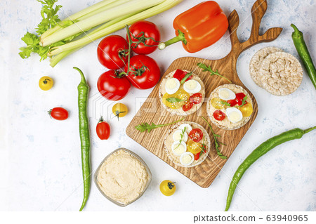 Open sandwiches of rice cakes with hummus , vegetables and quail egg, healthy breakfast or lunch Open sandwiches of rice cakes with hummus , vegetables and quail egg, healthy breakfast or lunch 63940965