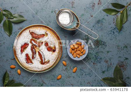Homemade rustic plum cake with powdered sugar and almond,top view 63941178
