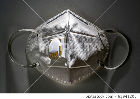 N95 mask on white table with dramatic contrasty lighting 63941203