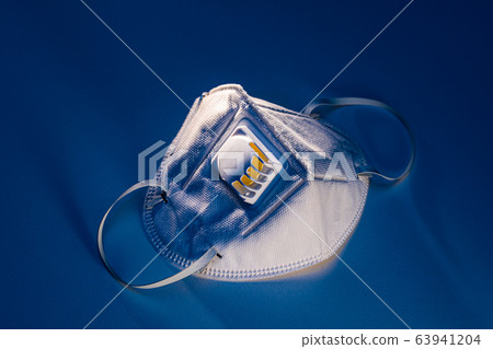 N95 mask on white table with dramatic contrasty lighting 63941204