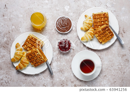 Delicious breakfast with coffee, orange juice, waffles,croissants,jam,nut paste on light background,top view 63941256