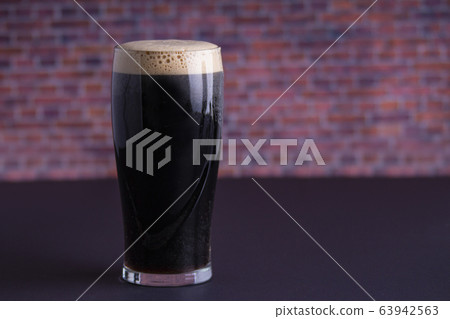 A Guinness dark Irish dry stout beer glass that A Guinness dark Irish dry stout beer glass that 63942563