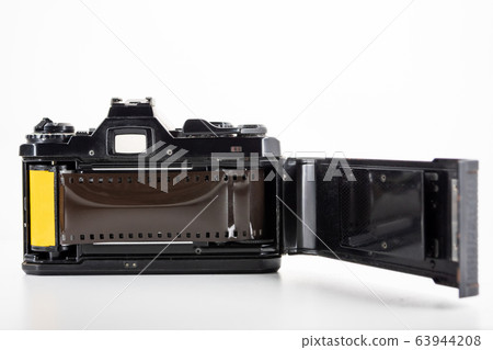 Single lens reflex camera and a film roll on a white background. Single lens reflex camera and a film roll on a white background. 63944208