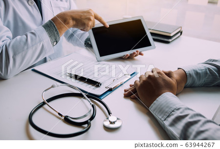 Asian doctor talking the patient at clinic while Asian doctor talking the patient at clinic while 63944267