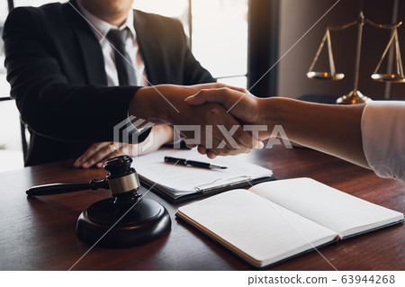 Lawyer is currently shaking hands with the client 63944268