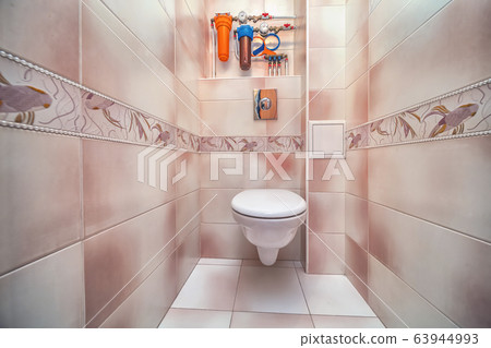 Toilet bowl in tiny toilet room with tile wall Toilet bowl in tiny toilet room with tile wall 63944993