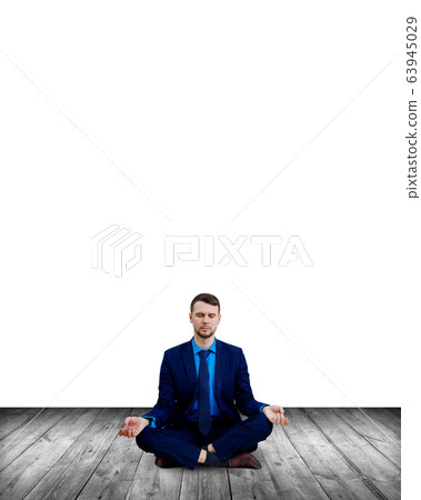 Calm businessman sitting in lotus pose and meditating. 63945029