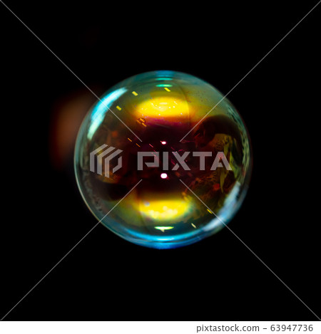 Multicolored soap bubble isolated on a black Multicolored soap bubble isolated on a black 63947736