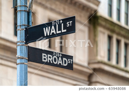 Wall Street "WALL ST" sign and broadway street over NYSE stock market exchange building background. The New York Stock Exchange locate in economy district, Business and sing of landmark concept Wall Street "WALL ST" sign and broadway street over NYSE stock market exchange building background. The New York Stock Exchange locate in economy district, Business and sing of landmark concept 63948086