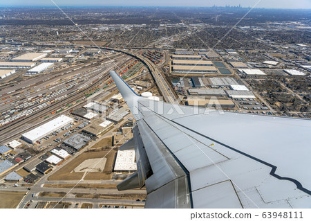 Aerial view of cargo trains and contrainers at the terminal railway which look through airplane windows,Aircraft Wing over cityscape,street and express way at the afternoon time,transportation concept Aerial view of cargo trains and contrainers at the terminal railway which look through airplane windows,Aircraft Wing over cityscape,street and express way at the afternoon time,transportation concept 63948111