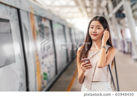 Young Asian woman passenger using and listening music via smart mobile phone in subway train station, japanese,chinese,Korean lifestyle, leisure and daily life, commuter and transportation concept Young Asian woman passenger using and listening music via smart mobile phone in subway train station, japanese,chinese,Korean lifestyle, leisure and daily life, commuter and transportation concept 63948430