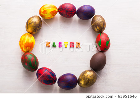 Multi-colored wooden letters making up the words happy easter and decorative colourful eggs on a white background with copy space. 63951640