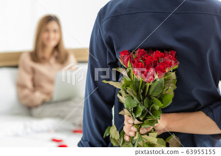 Man hiding flower at back. 63955155