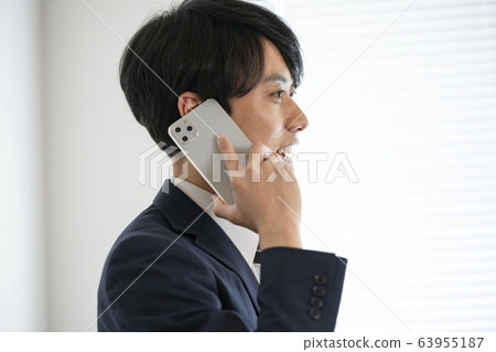 A young man talking on a smartphone A young man talking on a smartphone 63955187