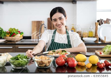 Woman eating vegetable salad Woman eating vegetable salad 63955645
