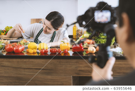 Woman show cooking to video camera Woman show cooking to video camera 63955646