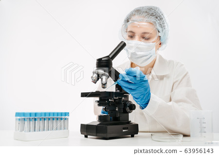 female scientist working with powerful microscope and reagent in clinic female scientist working with powerful microscope and reagent in clinic 63956143