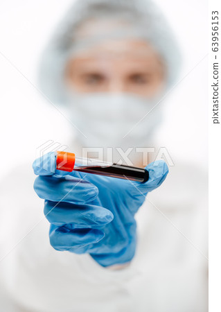 professional assistant holding tube of blood to make coronavirus test in clinic 63956153