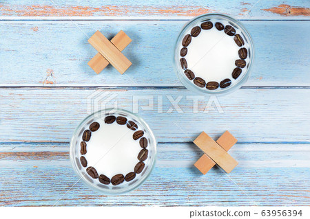 Noughts and crosses from glasses with milk and wooden blocks 63956394