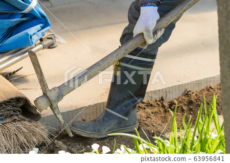 Workers digging trenches with pickaxes Workers digging trenches with pickaxes 63956841