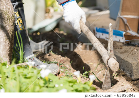 Workers digging trenches with pickaxes 63956842