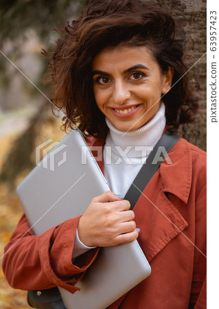 Confident woman with laptop outdoors stock photo 63957423